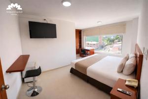 a hotel room with a bed and a flat screen tv at Hotel Dorado Gold in Bogotá