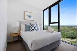 a bedroom with a large bed and a large window at The Gallery Broadbeach - Hosted by Gold Coast Luxury Resorts in Gold Coast