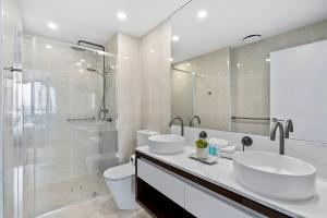 a white bathroom with two sinks and a shower at The Gallery Broadbeach - Hosted by Gold Coast Luxury Resorts in Gold Coast