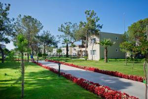 a walkway with red flowers in a park at Marvida Family Eco - Ultra All Inclusive & Kids Concept in Side