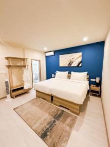 a bedroom with a large bed with a blue wall at Cher resort Maldives in Kamadhoo +24 photos