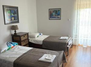 a hotel room with two beds and a night stand at Villa Coral in Novo Selo +7 photos