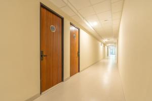an empty corridor in a hospital with wooden doors at Green Hill Service Apartment in Labuan Bajo