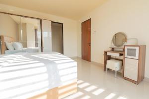 a bedroom with a bed and a tv in it at Green Hill Service Apartment in Labuan Bajo