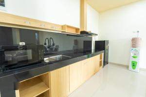 a kitchen with a microwave and a black counter top at Green Hill Service Apartment in Labuan Bajo