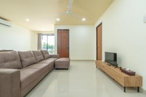 a living room with a couch and a flat screen tv at Green Hill Service Apartment in Labuan Bajo +22 photos