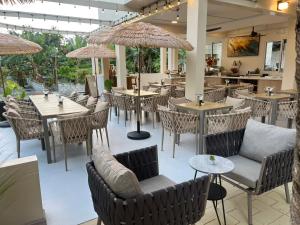 a restaurant with tables and chairs and umbrellas at Cher resort Maldives in Kamadhoo