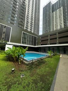 a swimming pool in front of a building with tall buildings at Marexe in Tabok