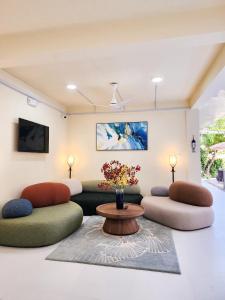 a living room with two couches and a table at Cher resort Maldives in Kamadhoo