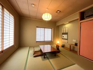 a living room with a table and two windows at Renovated room! Japanese inn Matsumoto in Ichinoseki