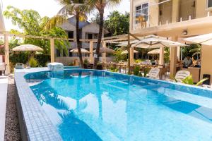 a large swimming pool with blue water in a hotel at Cher resort Maldives in Kamadhoo