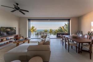 a living room with a couch and a table and a dining room at EEB TI KAAN TULUM - Luxury Oceanfront Residences in Tulum