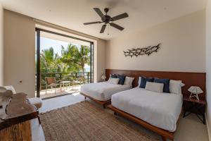 a bedroom with two beds and a balcony at EEB TI KAAN TULUM - Luxury Oceanfront Residences in Tulum +63 photos