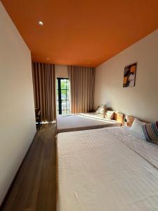 two beds in a bedroom with an orange ceiling at ACIS SmartHome NovaWorld in Bình Tú +25 photos