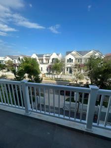 a white fence with houses in the background at ACIS SmartHome NovaWorld in Bình Tú