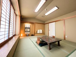 a room with a table in a room with windows at Renovated room! Japanese inn Matsumoto in Ichinoseki