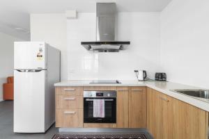 a kitchen with a refrigerator and a stove top oven at Rainbow Motel Queanbeyan in Queanbeyan
