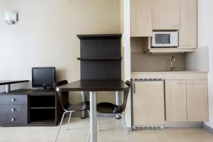 uma pequena cozinha com uma secretária e uma mesa com cadeiras em Residencia Universitaria Damia Bonet em Valência