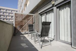 a balcony with two chairs on a building at Residencia Universitaria Damia Bonet in Valencia