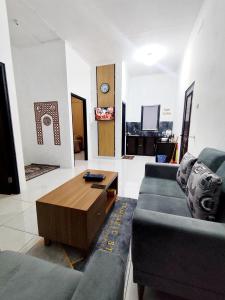 a living room with a couch and a coffee table at Griya Alborz Dieng in Garung