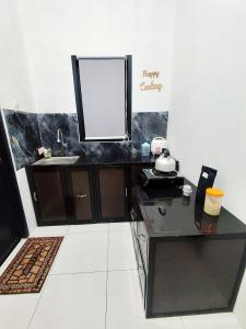 a black desk with a mirror and a sink at Griya Alborz Dieng in Garung