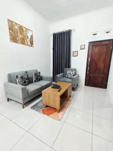 a living room with two couches and a coffee table at Griya Alborz Dieng in Garung