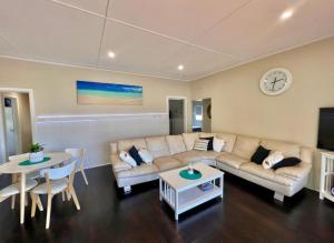 a living room with a couch and a table at Barefoot and Beach Bound by Book Jervis Bay in Vincentia