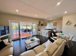 a living room with a couch and a table at Barefoot and Beach Bound by Book Jervis Bay in Vincentia +9 photos