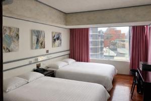 a hotel room with two beds and a window at Fudi Hotel in Taichung