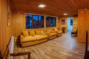 a living room with a couch and chairs in it at Hostal Royal Austral in Coihaique