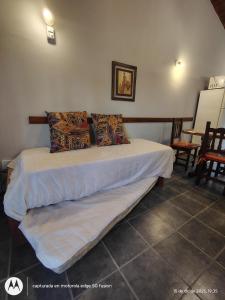 a bed with white sheets and pillows in a room at CHALET económico cerca del Mar in Costa Azul