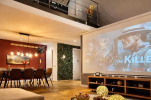 a large projection screen in a living room with a table and chairs at Luxury Loft Duplex Penthouse Of 190m2 & Free Parking ! in Brussels