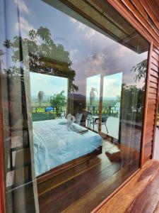 a room with a large glass window with a bed at Phunapat camping Pool villa in Ban Nong Chaeng