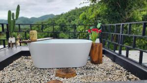 a white bath tub sitting on top of a balcony at Phunapat camping Pool villa in Ban Nong Chaeng