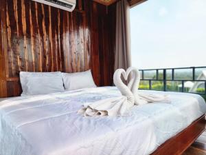 a bed with two swans made out of towels at Phunapat camping Pool villa in Ban Nong Chaeng