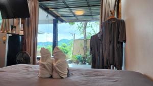 a pair of feet sitting on top of a bed at Phunapat camping Pool villa in Ban Nong Chaeng