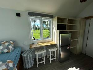 a small kitchen with a desk and a window in a room at Beachfront Tiny House - Eden Pod with FREE Rowboat in Nathon Bay