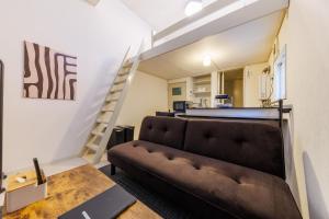 a living room with a couch and a staircase at Gran Form Kita 12-jo in Kita-sanjō