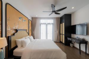 a hotel room with a bed and a ceiling fan at AviCasa T21 in Gò Công
