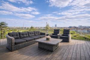 two couches and a coffee table on a deck at Luxury Loft Duplex Penthouse Of 190m2 & Free Parking ! in Brussels