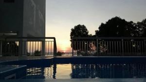 a swimming pool with a sunset in the background at Seaview Turtle Cove in Kampong Bugis