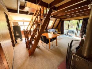 a dining room with a table and a staircase in a house at Danseys Pass Holiday Park in Oamaru