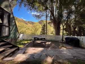 a picnic table in a yard next to a fence at Danseys Pass Holiday Park in Oamaru
