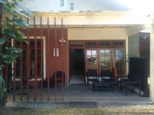 a porch of a building with chairs and a fence at De Gadri Ndalem Yogyakarta in Bantul