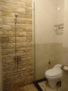 a bathroom with a toilet and a glass shower door at De Gadri Ndalem Yogyakarta in Bantul +38 photos