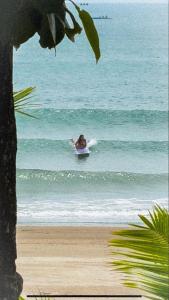 a person riding a wave on a surfboard in the ocean at The Stoked Hideout - Bagasbas Beach in Daet