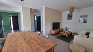 a living room with a wooden table and a couch at Villa Horizon Volcan in Saint-Philippe