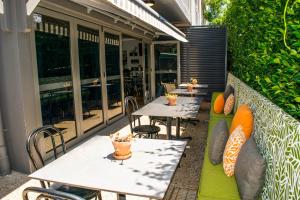 an outdoor patio with tables and chairs and windows at Potters Toowoomba Hotel in Toowoomba