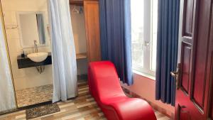 a bathroom with a red chair in front of a window at Nhật Minh Hotel in Thuan An