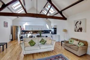 a living room with two couches and a kitchen at Annapurna Guest House in Lingwood